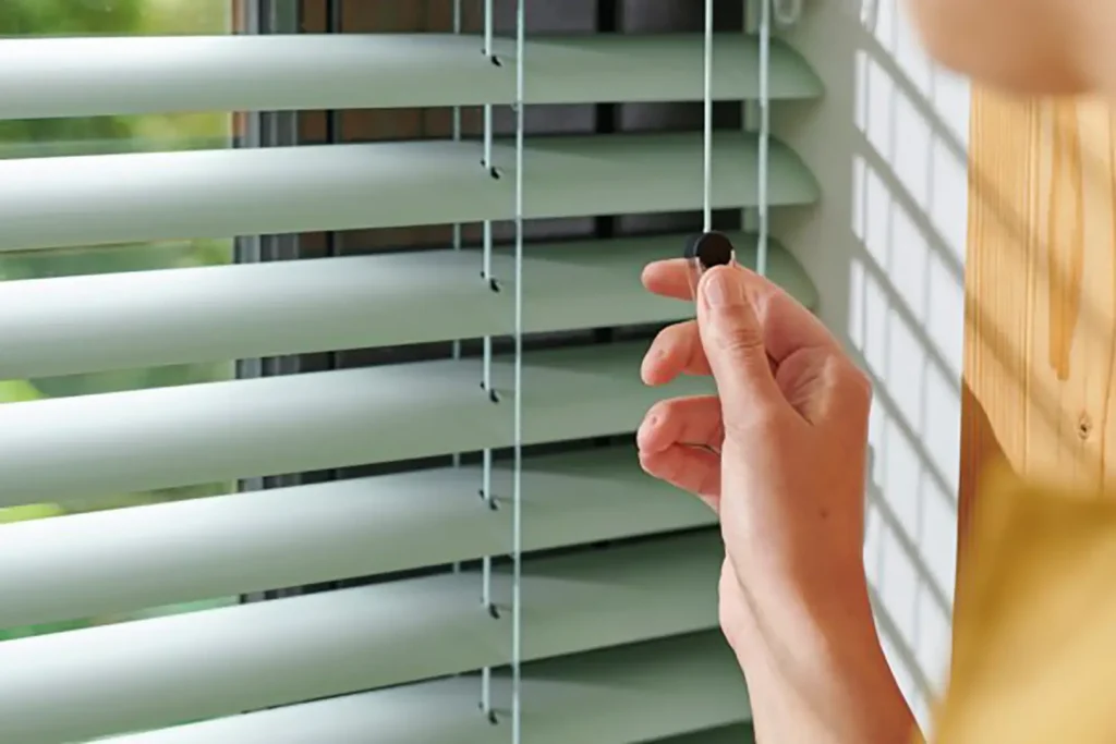Venetian Blinds Close Up Photo woman cord operating green slats crop
